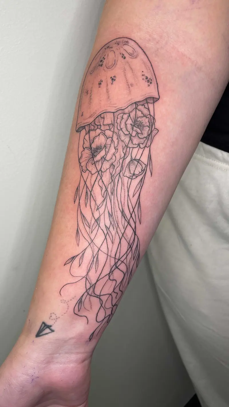 A lovely little jellyfish with some flowers 🌸 * * * #flowerfish #jellyfishtattoo #finelinetattooing #flowersandleaves…