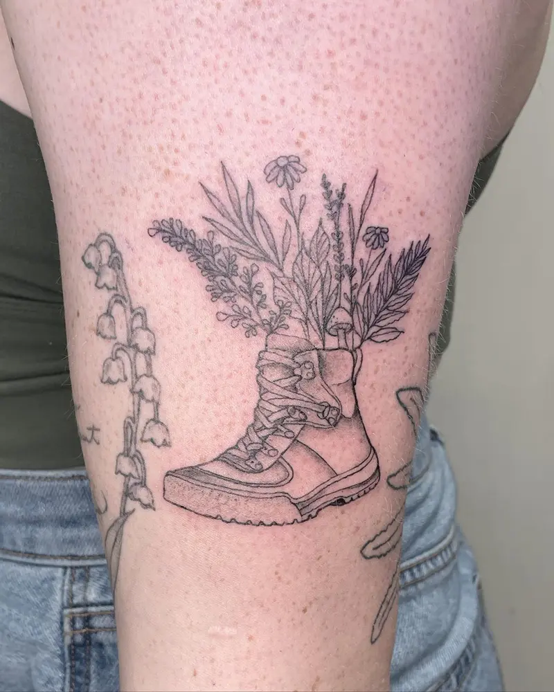 Hiking boots with flowers from over the weekend. * * * #hikingtattoo #hikingboot #hiking #wildflowers #mushrooms #fern…